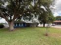 Charming blue home set back on a lush green lawn with mature trees and tidy landscaping at 1328 Edgewater Beach Dr, Lakeland, FL 33805