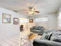 Bright living room with tile flooring, ceiling fan, and views into the dining area at 1405 Clinton St, Bartow, FL 33830