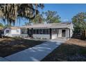 Bright single-story home with a covered porch, new walkway, and manicured lawn at 1507 Holly Rd, Lakeland, FL 33801