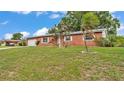 Charming brick home with a well-manicured lawn, attached garage, and mature landscaping at 1507 Neptune Dr, Lakeland, FL 33801