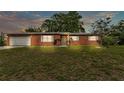 Charming brick home featuring a well-manicured lawn, attached garage, and traditional windows at 1507 Neptune Dr, Lakeland, FL 33801