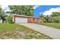 Brick home with an attached garage and a long driveway in a residential neighborhood at 1507 Neptune Dr, Lakeland, FL 33801