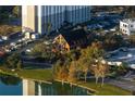 Aerial view of a brick building surrounded by trees, parking, and the lakefront at 200 Lake Morton Dr # 100, Lakeland, FL 33801
