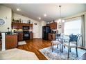 Open-concept kitchen with dark wood cabinets, appliances, adjacent dining area, and wood flooring at 2040 Chickadee St, Bartow, FL 33830