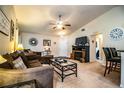 Spacious living room features neutral carpet, ceiling fan, cozy seating, and stylish decor at 2040 Chickadee St, Bartow, FL 33830