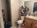 Practical bathroom with wooden vanity, toilet, walk-in shower and mirrored wall at 208 Center St, Auburndale, FL 33823