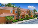 Lovely two-story condo with a Spanish tile roof, orange stucco, and mature landscaping at 2683 Corvette Ln, Kissimmee, FL 34746