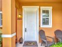 Inviting front porch with chairs and stylish address number on the exterior of this lovely home at 2683 Corvette Ln, Kissimmee, FL 34746