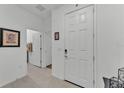 Clean and bright hallway featuring neutral tile flooring, white walls, and a white front door at 280 Pershing St, Bartow, FL 33830