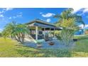 Enclosed Florida room with an outdoor entertaining space, manicured landscaping, and seating at 3016 Wood Duck Dr, Polk City, FL 33868