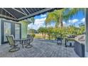A lovely outdoor patio features a dining area, grill, and scenic views of the surrounding landscape at 3016 Wood Duck Dr, Polk City, FL 33868