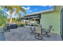 Inviting outdoor space with a patio table, chairs, awning, grill, and serene backyard view at 3016 Wood Duck Dr, Polk City, FL 33868