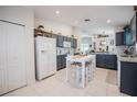 Bright kitchen features gray cabinets, granite countertops, white appliances, and a cozy dining table at 3873 Hampton Hills Dr, Lakeland, FL 33810
