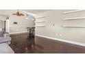 Bright living room with dark hardwood floors, fan, dining area, and floating shelves at 402 W Patterson St, Lakeland, FL 33803