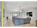 Spacious living room with tile flooring, a ceiling fan, and a large sectional sofa at 404 Willow Run, Lakeland, FL 33813