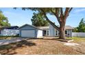 Charming single-story home with a well-maintained lawn, a two-car garage and mature shade tree at 417 Yolonda Ct, Lakeland, FL 33809