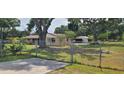View of home and detached garage from fenced yard, highlighting a spacious lot with mature trees at 5211 Berkley Rd, Auburndale, FL 33823