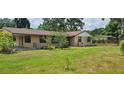 Single story home with a large front yard and attached carport, offering a cozy suburban feel at 5211 Berkley Rd, Auburndale, FL 33823