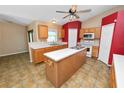 Open kitchen with wood cabinets, a center island, tiled flooring, and modern appliances at 5733 Oakwood Knoll Dr, Lakeland, FL 33811