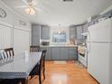 Cozy kitchen featuring gray cabinetry, wooden floors, and stainless-steel appliances at 6087 Southern Oaks Se Dr, Winter Haven, FL 33884