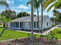Charming single-story home boasts a well-manicured lawn, mature palm trees, and a screened-in porch at 6194 Sanderling Dr, Lakeland, FL 33809