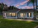 Well-lit single-story home at dusk, featuring a screened-in porch perfect for enjoying tranquil evenings at 6194 Sanderling Dr, Lakeland, FL 33809