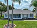 Quaint single-story home with white exterior, complemented by a well-kept lawn and inviting front porch at 6194 Sanderling Dr, Lakeland, FL 33809