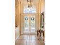 Elegant foyer with decorative front doors, neutral tile flooring, and high ceilings at 645 Whisper Woods Dr, Lakeland, FL 33813