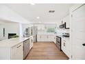 Beautiful kitchen with stainless appliances, granite counters, laminate flooring, and white shaker cabinets at 6527 Fernwood Dr, Lakeland, FL 33810