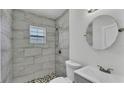 Modern bathroom with tiled shower, mosaic floor, and sleek fixtures at 725 Avenue B Sw, Winter Haven, FL 33880