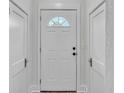 Inviting entryway featuring a white front door with a half-round window and neutral wall tones at 725 Avenue B Sw, Winter Haven, FL 33880