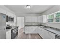 Bright kitchen featuring white cabinets, stainless steel appliances, and modern countertops at 725 Avenue B Sw, Winter Haven, FL 33880