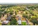 An aerial view shows this home nestled in a neighborhood surrounded by lush green trees at 960 Lila St, Bartow, FL 33830