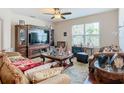 Cozy living room featuring a plush sofa, wooden furniture, and large windows at 120 Grove Branch Rd, Winter Haven, FL 33880