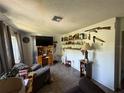Cozy living room features tile flooring, decorative shelving and natural light at 1208 Lowry Ave, Haines City, FL 33844