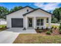Charming single-story home featuring a black garage door and a well-manicured lawn at 1242 Dorothy St, Lakeland, FL 33815