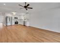 Bright living room with hardwood floors adjacent to a modern kitchen featuring stainless steel appliances at 1246 Dorothy St, Lakeland, FL 33815