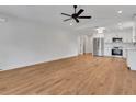 Bright living room with hardwood floors adjacent to a modern kitchen featuring stainless steel appliances at 1246 Dorothy St, Lakeland, FL 33815