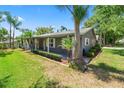 Gray home exterior with palm trees and manicured landscaping at 1628 Lakewood S Dr, Lakeland, FL 33813
