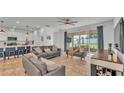 Open-concept living space with tile floors, stylish furnishings, and sliding glass doors to the patio at 1725 Hill Top Dr, Dundee, FL 33838