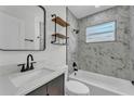 Modern bathroom featuring marble-patterned tile, a sleek vanity, and a shower-tub combination at 1728 Bush Ave, Lakeland, FL 33805