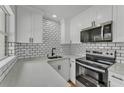 Contemporary kitchen with white cabinets, subway tile backsplash, stainless steel appliances, and quartz countertops at 1728 Bush Ave, Lakeland, FL 33805