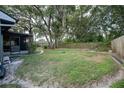 Large, shaded backyard featuring a fenced perimeter, screened porch, and mature shade trees at 1920 Indian Trails Ct, Lakeland, FL 33813