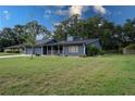 Lovely single story home with lush front lawn, mature trees, and a charming screened in front porch at 1920 Indian Trails Ct, Lakeland, FL 33813