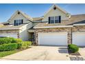 Beautiful townhome featuring a stone facade, attached two-car garage, and manicured landscaping at 2047 Winterset Dr, Lakeland, FL 33813