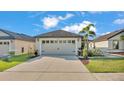 Two-car garage with decorative details and palm trees in a well-maintained front yard at 2293 Caspian Dr, Lakeland, FL 33805