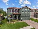 Charming two-story home boasts an attached two-car garage, brick-paved driveway, and lush landscaping at 2317 Bella Luna Cir, Lakeland, FL 33810