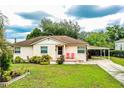 Traditional home with a cozy front porch and a convenient attached carport in a landscaped yard at 2710 Fairmount Ave, Lakeland, FL 33803