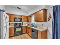 Functional kitchen featuring wood cabinets, laminate countertops, and black appliances at 306 Olmo Ct, Winter Haven, FL 33880
