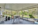 Enclosed outdoor porch with seating and a peaceful backyard view at 306 Olmo Ct, Winter Haven, FL 33880